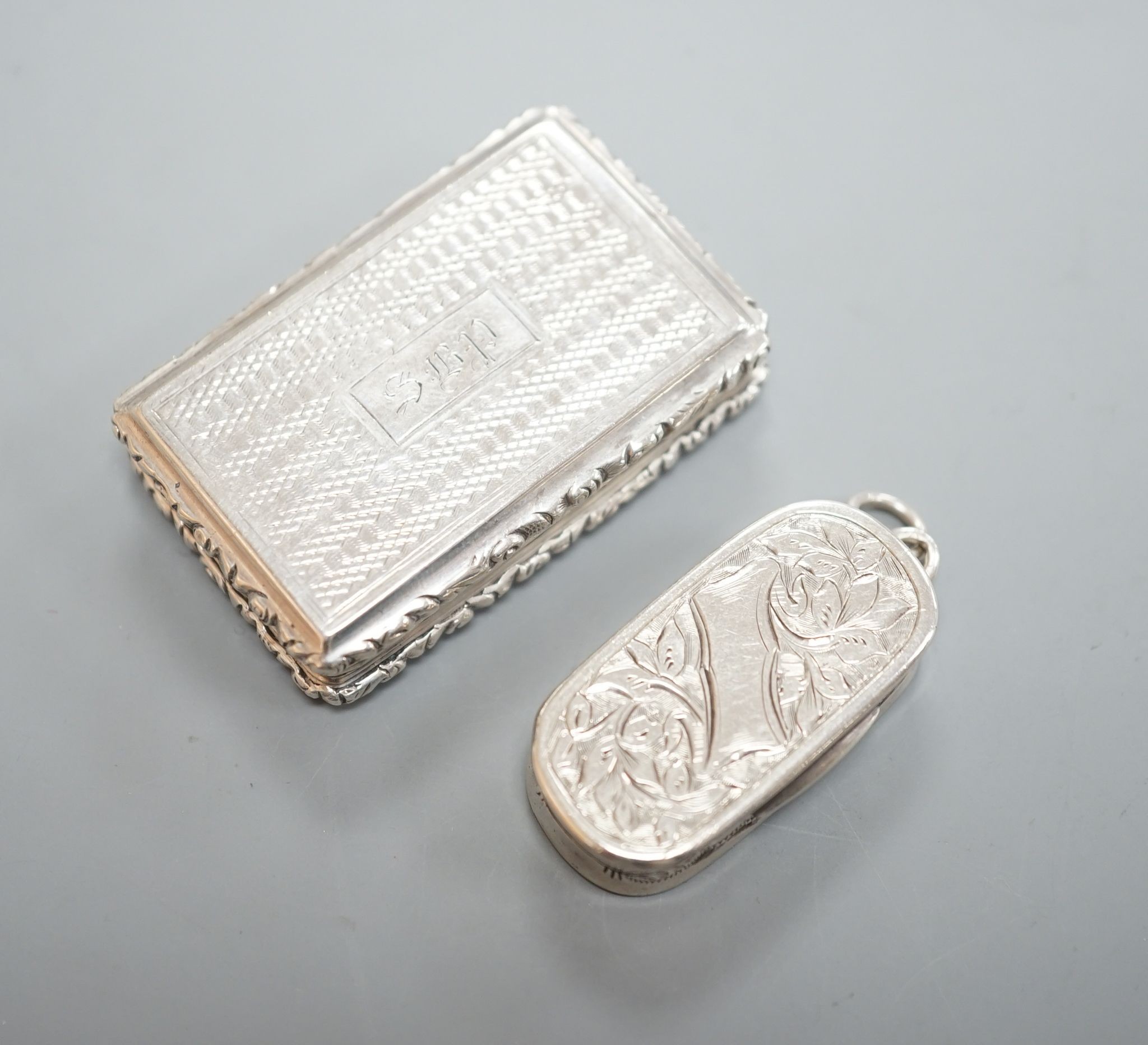 A William IV engraved silver rectangular vinaigrette, with engraved initials, Taylor & Perry, Birmingham, 1833, 42mm and a later oval vinaigrette, by George Unite.